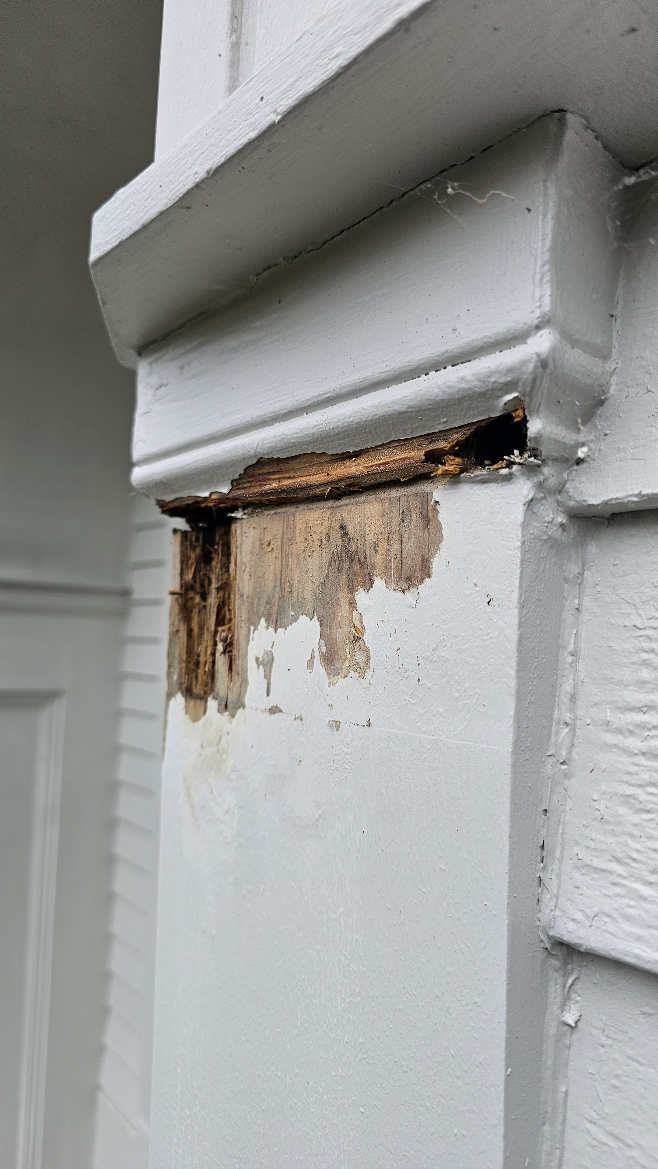 Soffit and fascia at the Natick property showing deteriorated wood and paint failure at a corner, visible before siding was removed.