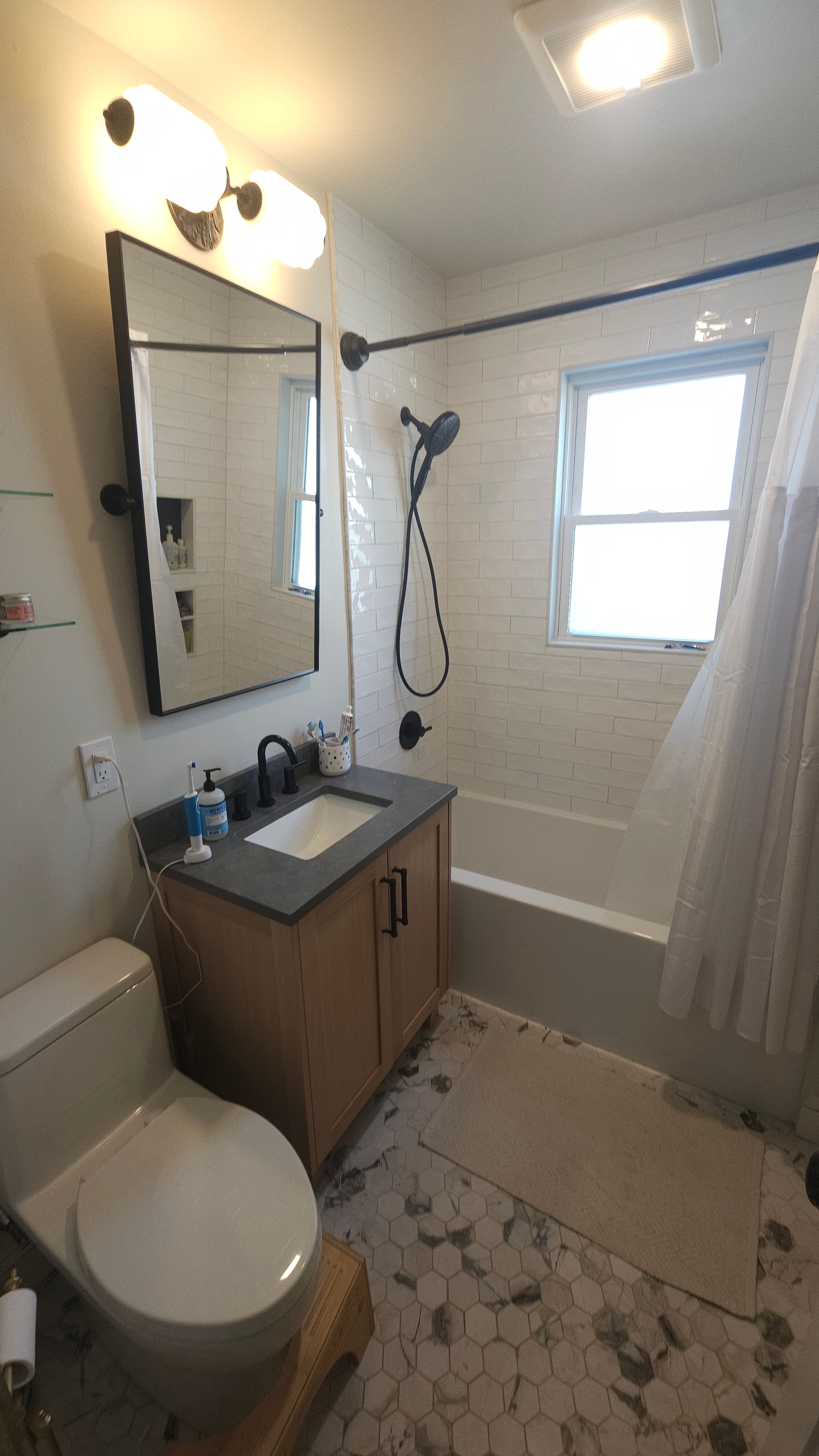 Finished bathroom — white subway tile, vanity, black fixtures
