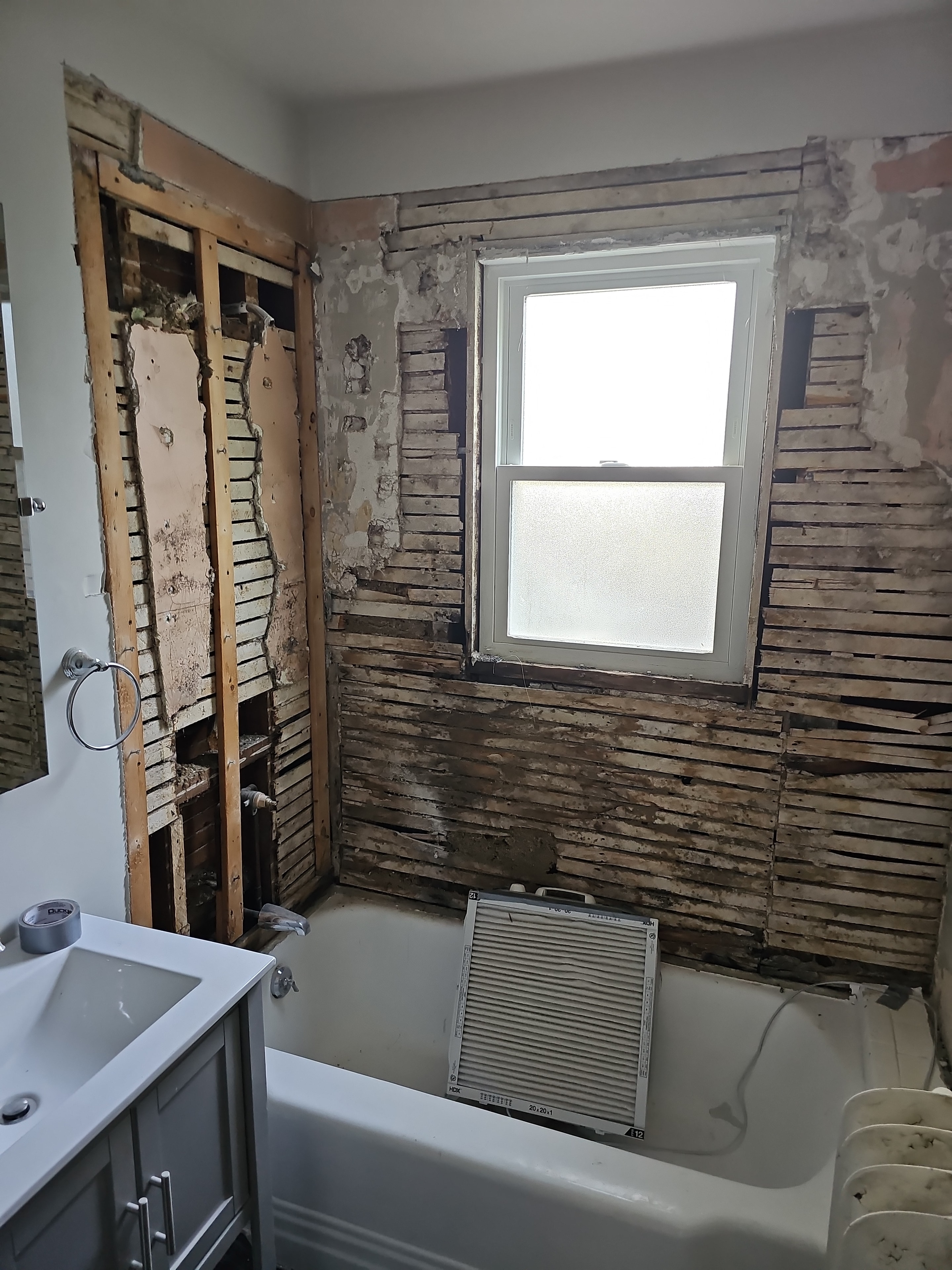 Bathroom after demolition — exposed lath and framing, West Roxbury MA