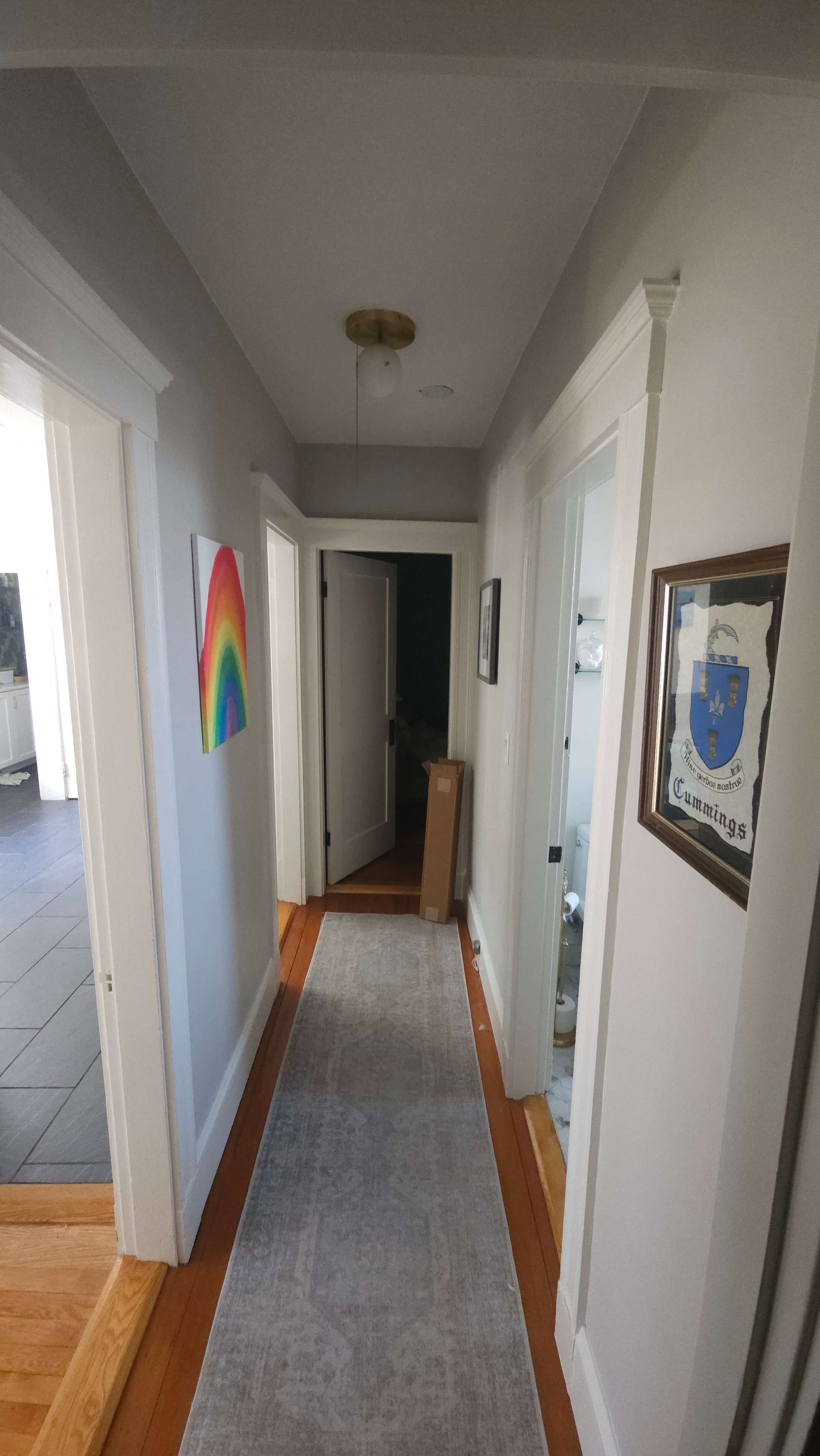 Hallway before — plain walls, coffered ceiling, wood floor